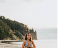 Девушка медитирует на берегу озера